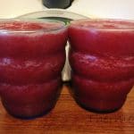 cherry banana mocktails, two glasses of pink slushie drink on wooden board in front of thermomix