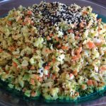 Large, full dish of chopped coleslaw salad. Sesame slaw is topped with sesame seeds