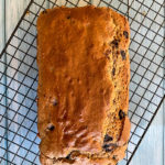 blueberry and lemon loaf on cooling rack on aqua wood counter top