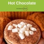 thermomix hot chocolate in mug with marshmallows being held by girl in snuggly orange jumper