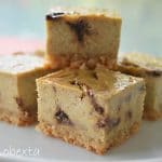 strawberry swirl baked cheesecake made in thermomix, cut into squares and sitting on white plate. Blurred background