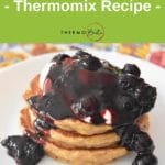 blueberry sauce on pancake stack on white plate on colourful placemat. Green banner above, with recipe title and Thermobexta logo