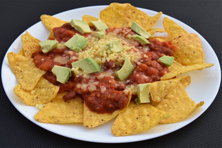 nachos on white plate, black background