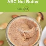 abc nut butter thermomix recipe, photo from above, nuts on green tablecloth around jar