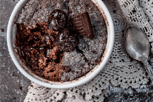 thermomix choc pudding in white bowl, with doily and spoon