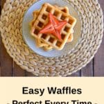 pin three thermomix waffles from birds eye view with maple syrup and strawberries on woven placemat on wooden table