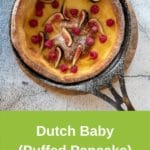 Dutch baby in cast iron pan on rustic background