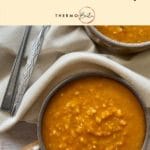 bowl and part bowl of spicy tomato lenti lsoup on wooden backdrop with cream fabric and two spoons