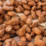 Close up of sugar and spice almonds, slight background showing of wooden table and beige fabric