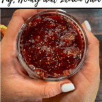 text 'Thermobexta thermomix fig, honey and lemon jam' at top, then image of jam in jar being held by two hands, Birdseye view. Thermobexta logo in black strip along bottom