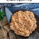 roasted capsicum dip pin with title up top and thermobexta logo underneath image of dip in a black leaf shaped dish on a plate with crackers around it. Blue patterned placemat underneath plate.