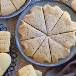 sliced round shortbread thermomix made, sitting on a round plate, surrounded by pieces of shortbread