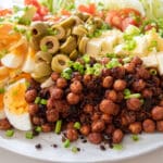 roasted chickpeas, eggs, chives, avocado, tomato, lettuce, cucumber, olives, fetta on plate