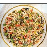 couscous salad pinterest pin photo of entire salad in glass dish with gold rim