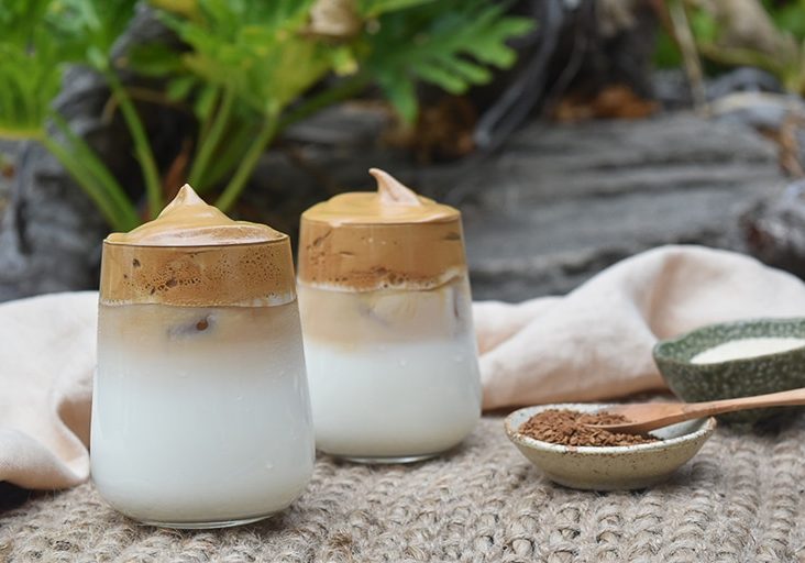 Two iced coffees, frothy toppings.