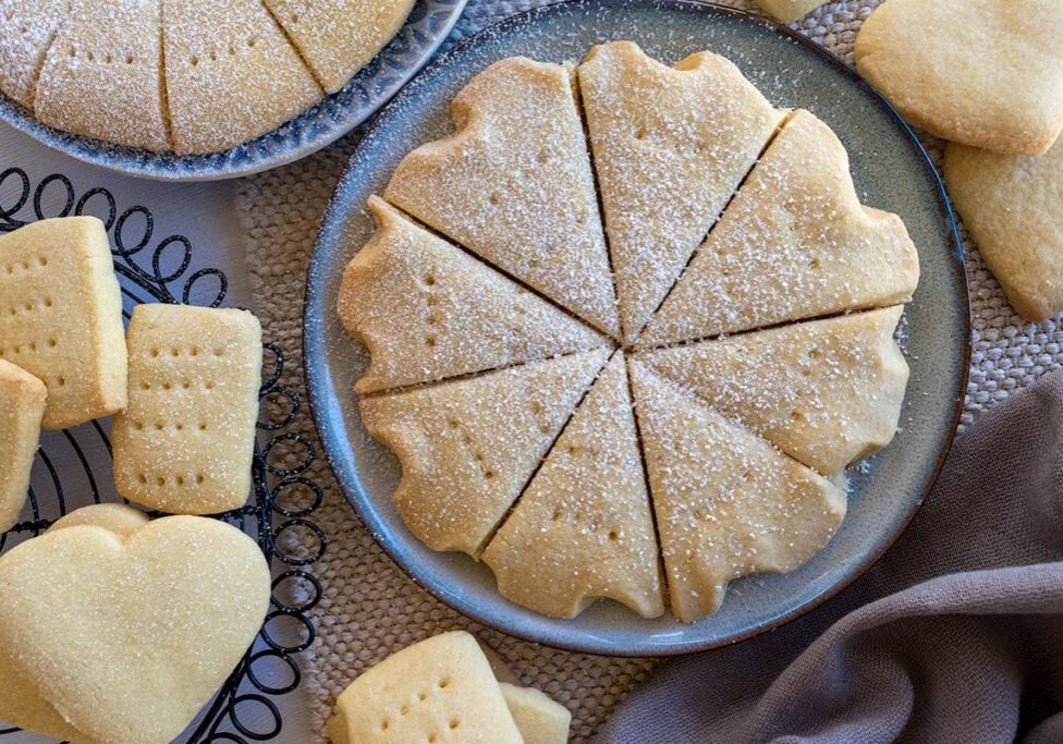sliced round shortbread thermomix made, sitting on a round plate, surrounded by pieces of shortbread